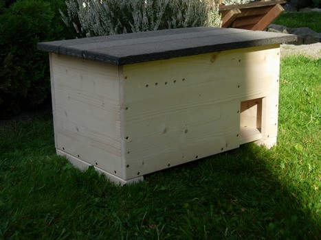 Igel-&Uuml;berwinterungskasten. Au&szlig;enansicht. Hergestellt aus nichbehandelten Fichtenholz. Materialst&auml;rke 18 mm. Verbindungen verschraubt. Das Pultdach hat einen seitlichen und vorderen Dach&uuml;berstand von 30 mm und ist mit besandeter Dachpappe ausgestattet. F&uuml;nf Bel&uuml;ftungsl&ouml;cher beugen Schimmelbildung vor und sorgen f&uuml;r ein gutes Raumklima. Zum Schutz vor Bodenfeuchtigkeit und Frost&uuml;bertragung sind Kanth&ouml;lzer als Standf&uuml;&szlig;e montiert und von untern mit Dachpappe zus&auml;tzlich gegen Kriechfeuchtigkeit gesch&uuml;tzt.